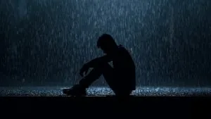 Lonely Silhouette Man Sitting in Rain