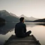 Man Sitting on Dock Looking at Lake