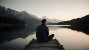 Man Sitting on Dock Looking at Lake