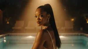 Rihanna Sitting Beside a Pool Under Golden Lights
