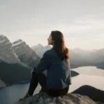 Woman Sitting on Mountain Edge