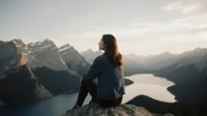 Woman Sitting on Mountain Edge